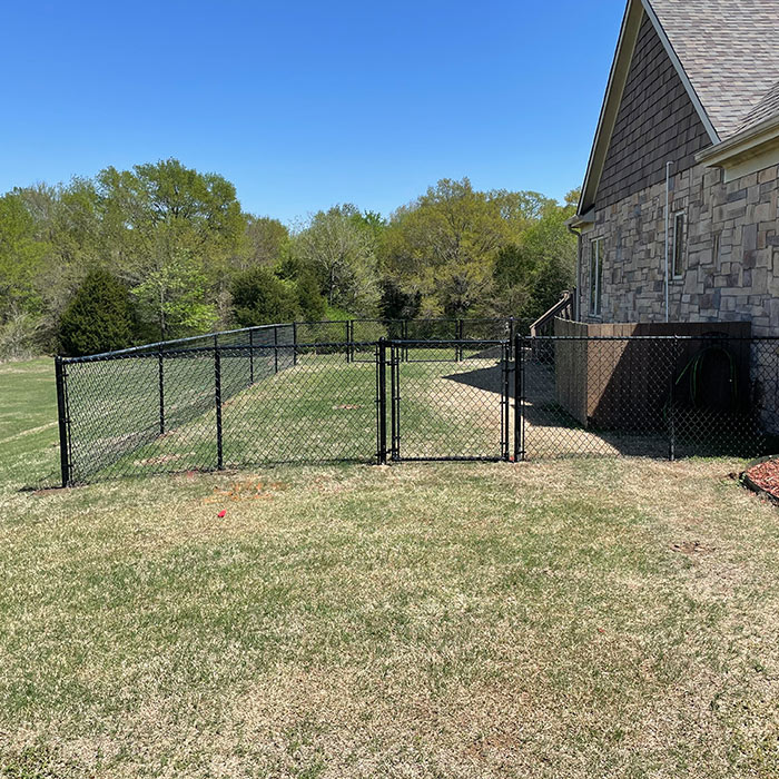 residential property backyard with small chain link fence installed calera ok